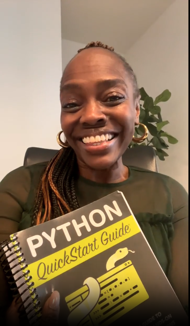 Person smiling, holding a Python QuickStart Guide book.