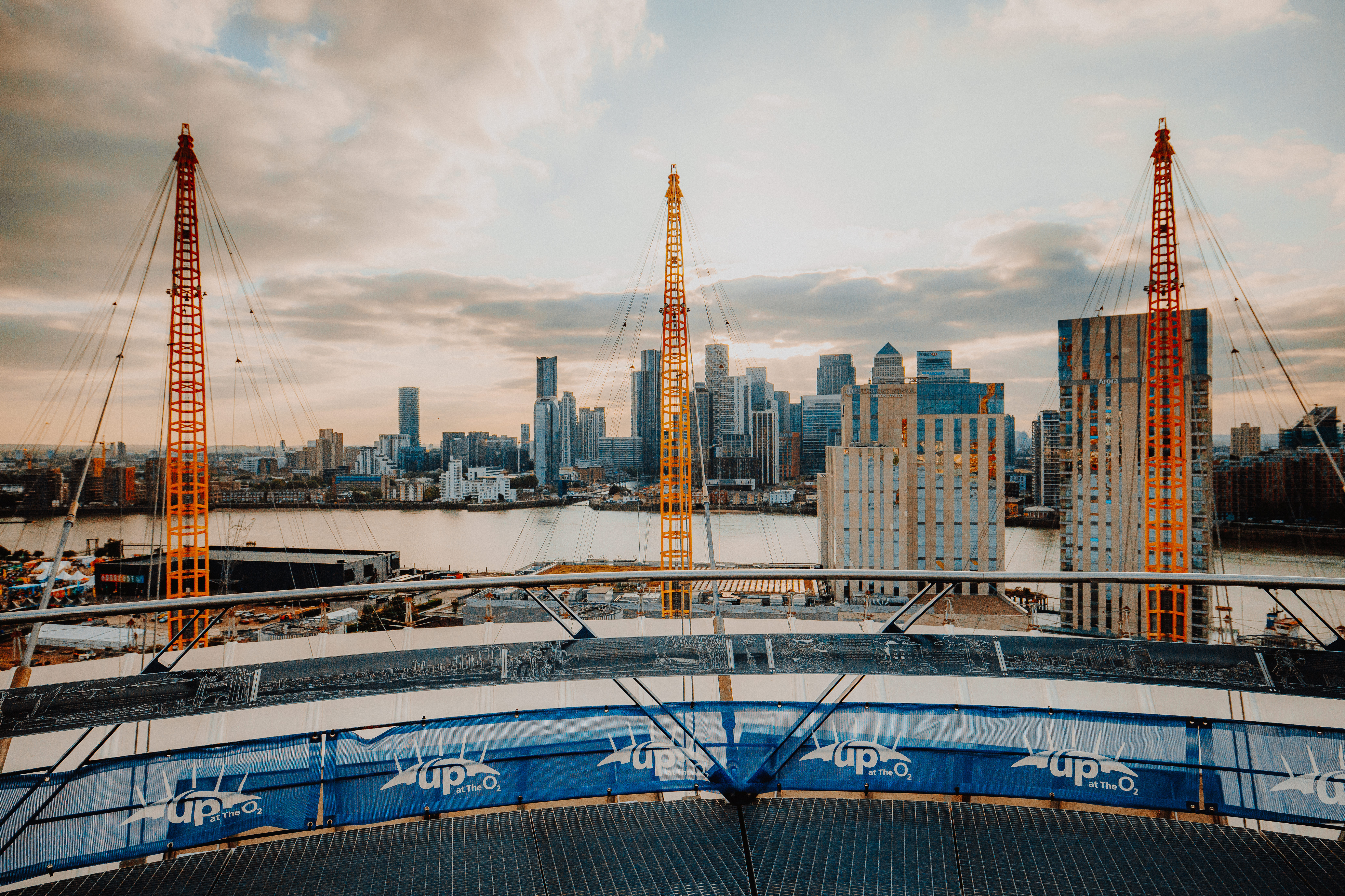 A wide-angle view of the London skyline from the 'Up at The O2' experience at sunset.
