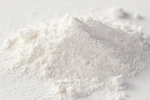 A pile of fine white powder on a smooth surface.