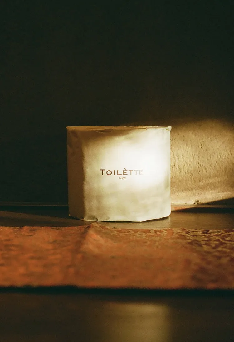 A single roll of toilet paper in a white wrapper with the words 'TOILÈTTE NYC'.