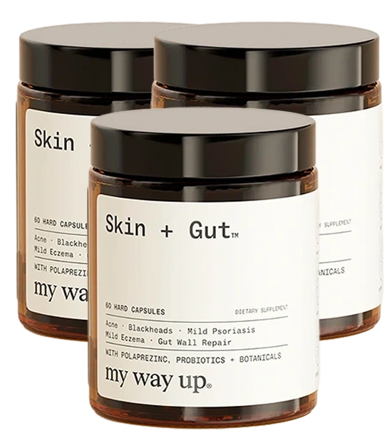 Three amber glass jars of Skin + Gut dietary supplement capsules from the brand my way up.