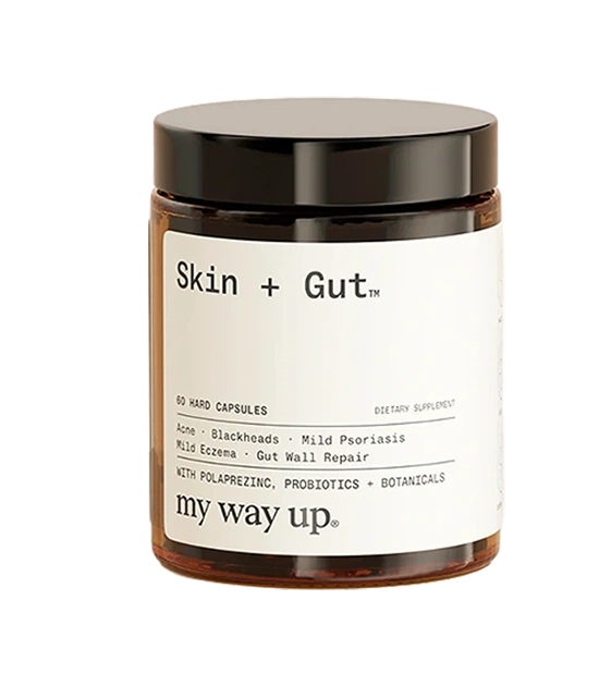 A brown jar of my way up Skin + Gut dietary supplement capsules against a solid green background.