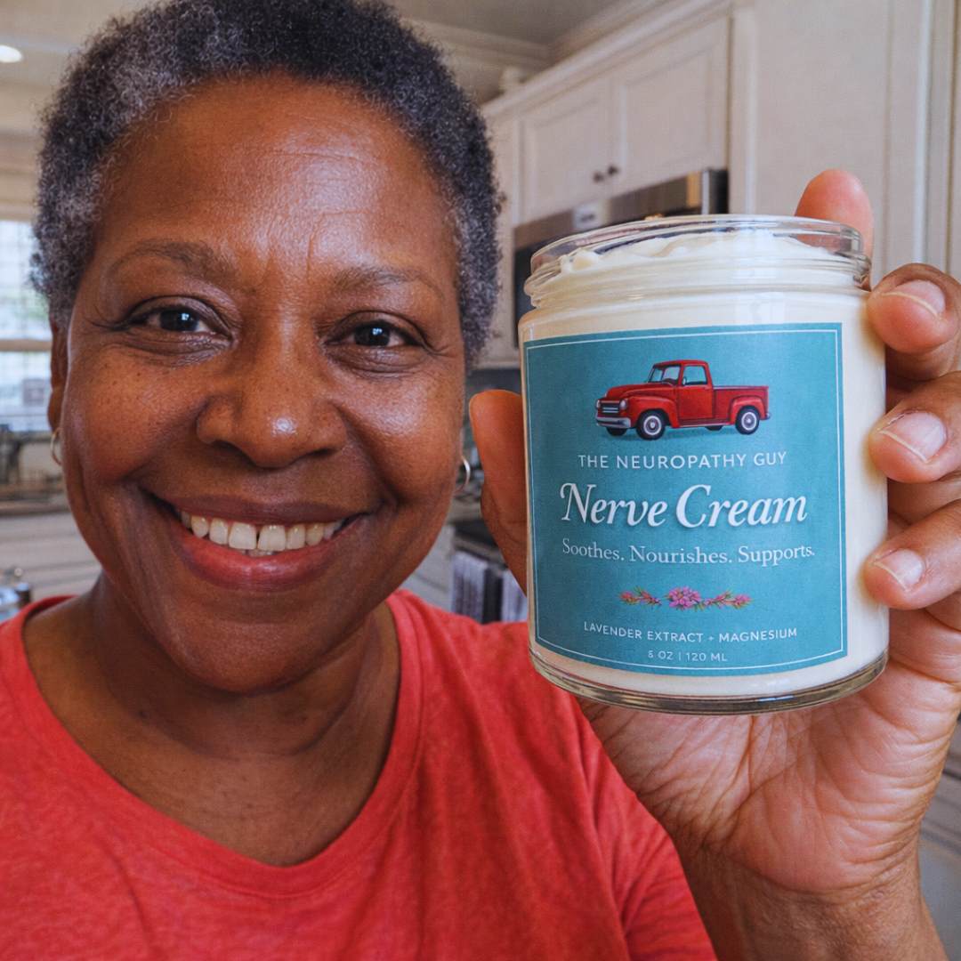 A smiling woman holds up a jar of The Neuropathy Guy Nerve Cream in her kitchen.