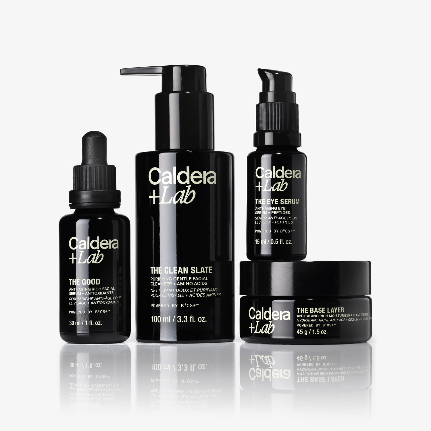 Four black skincare product bottles with labels, including droppers and pumps.