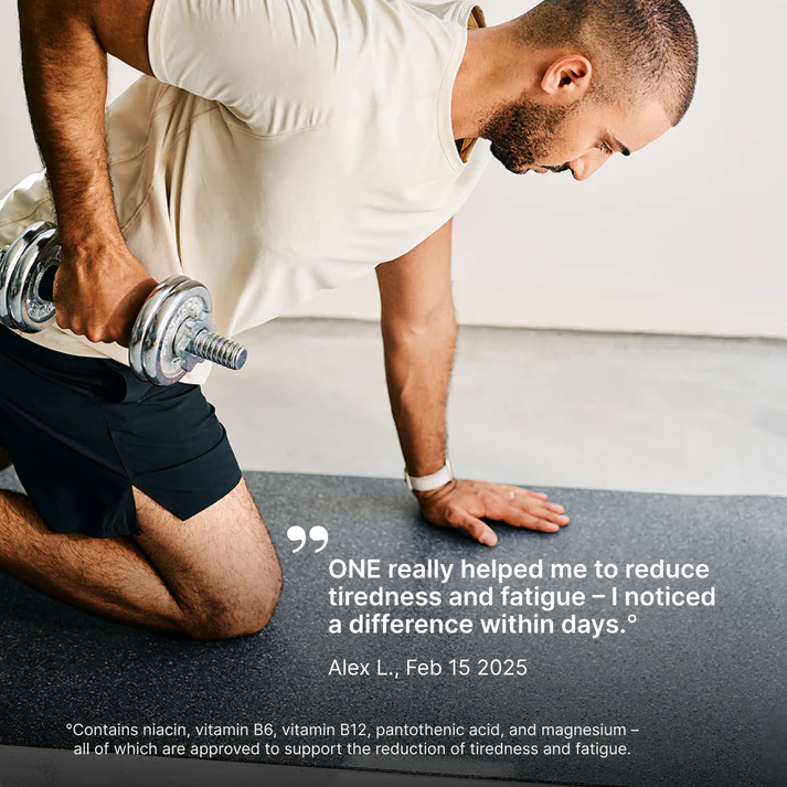 Man kneeling with one hand on knee, holding a dumbbell.