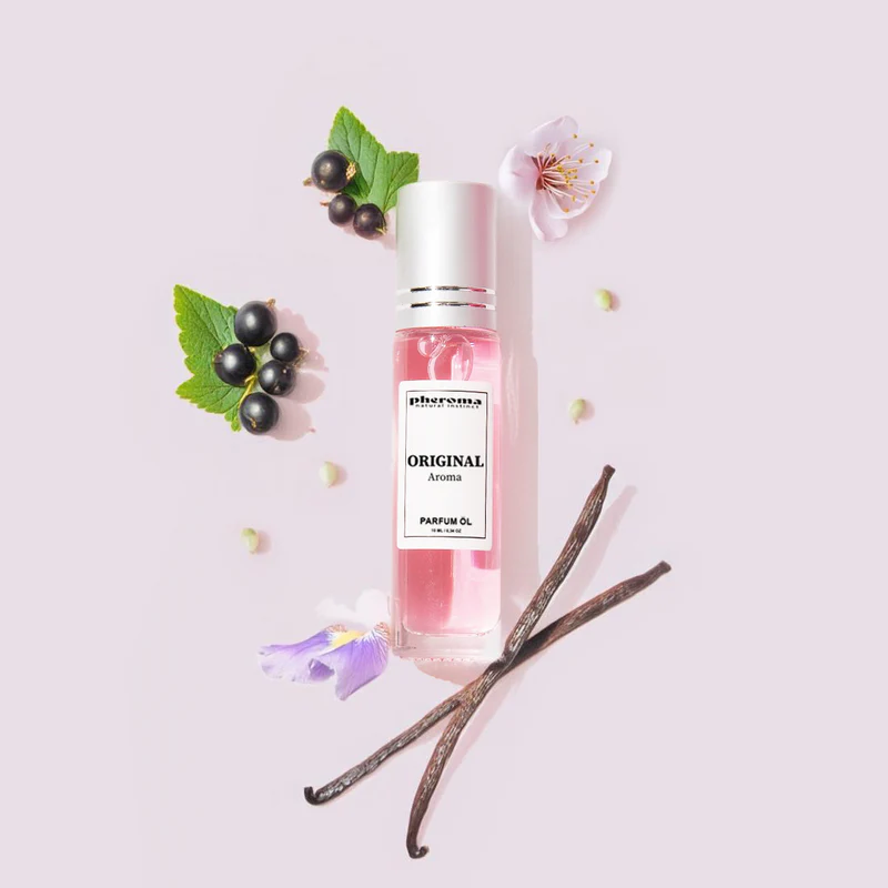 Pink perfume bottle with flowers, berries, and vanilla pods on light background.