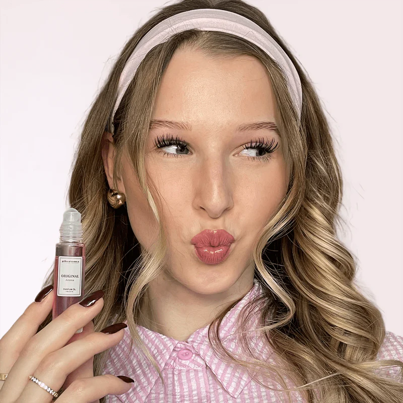 Person with headband holding a small bottle, puckering lips.