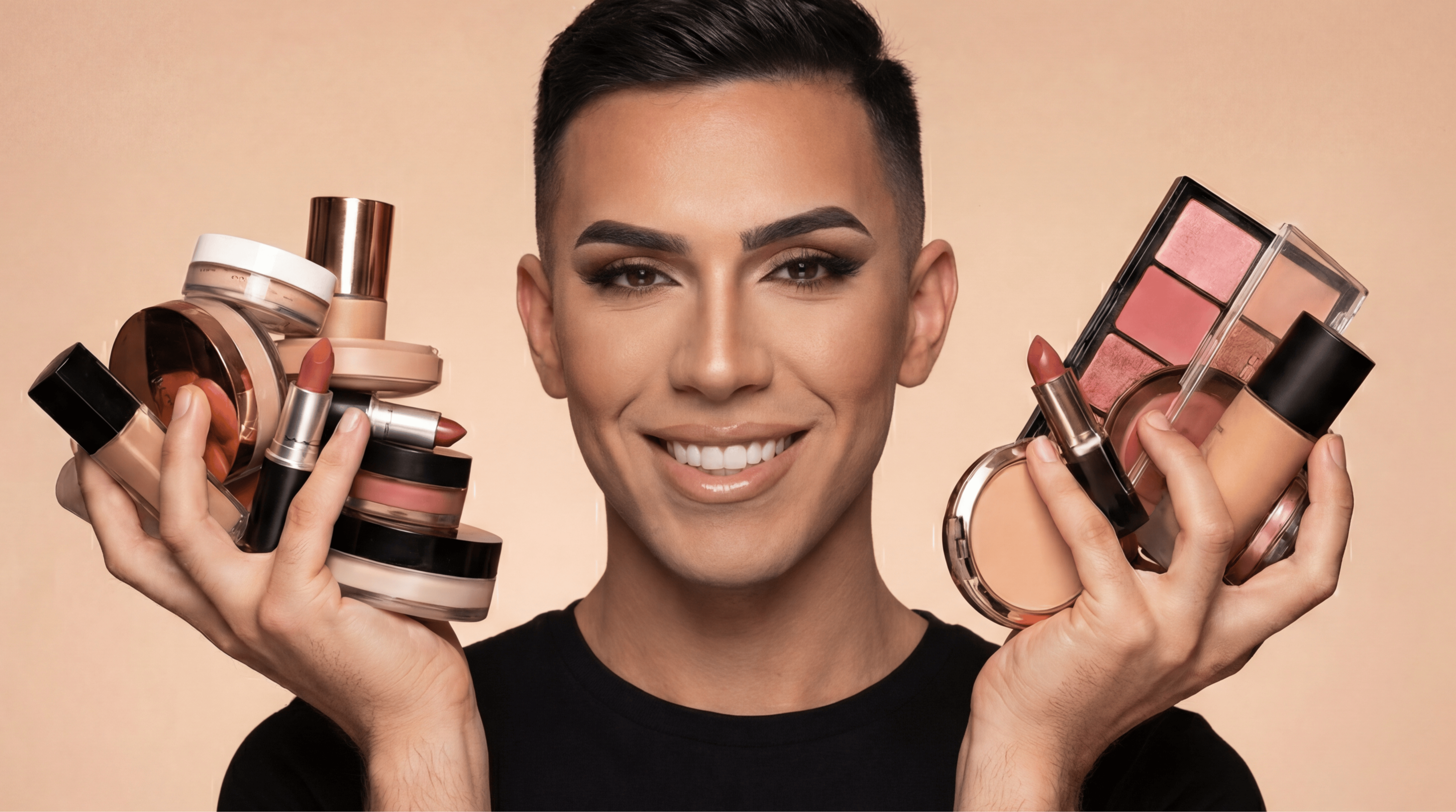 A smiling man wearing full makeup holds an assortment of cosmetic products in both hands.