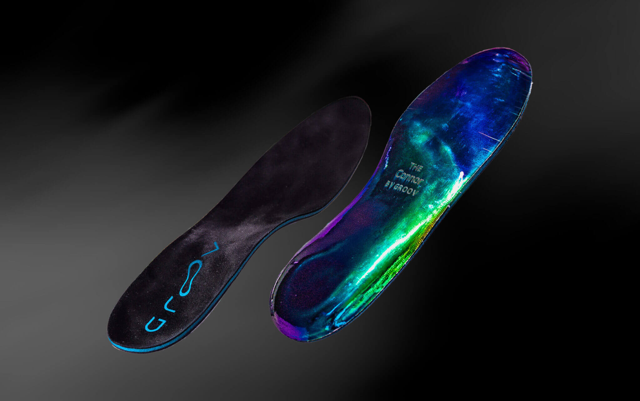 Two colorful shoe insoles on a dark background.