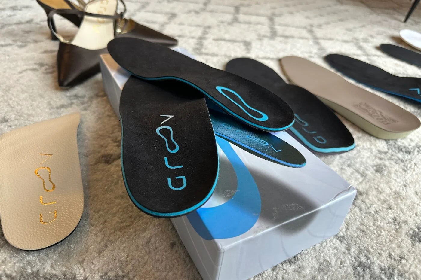 Various shoe insoles displayed on a carpeted floor.
