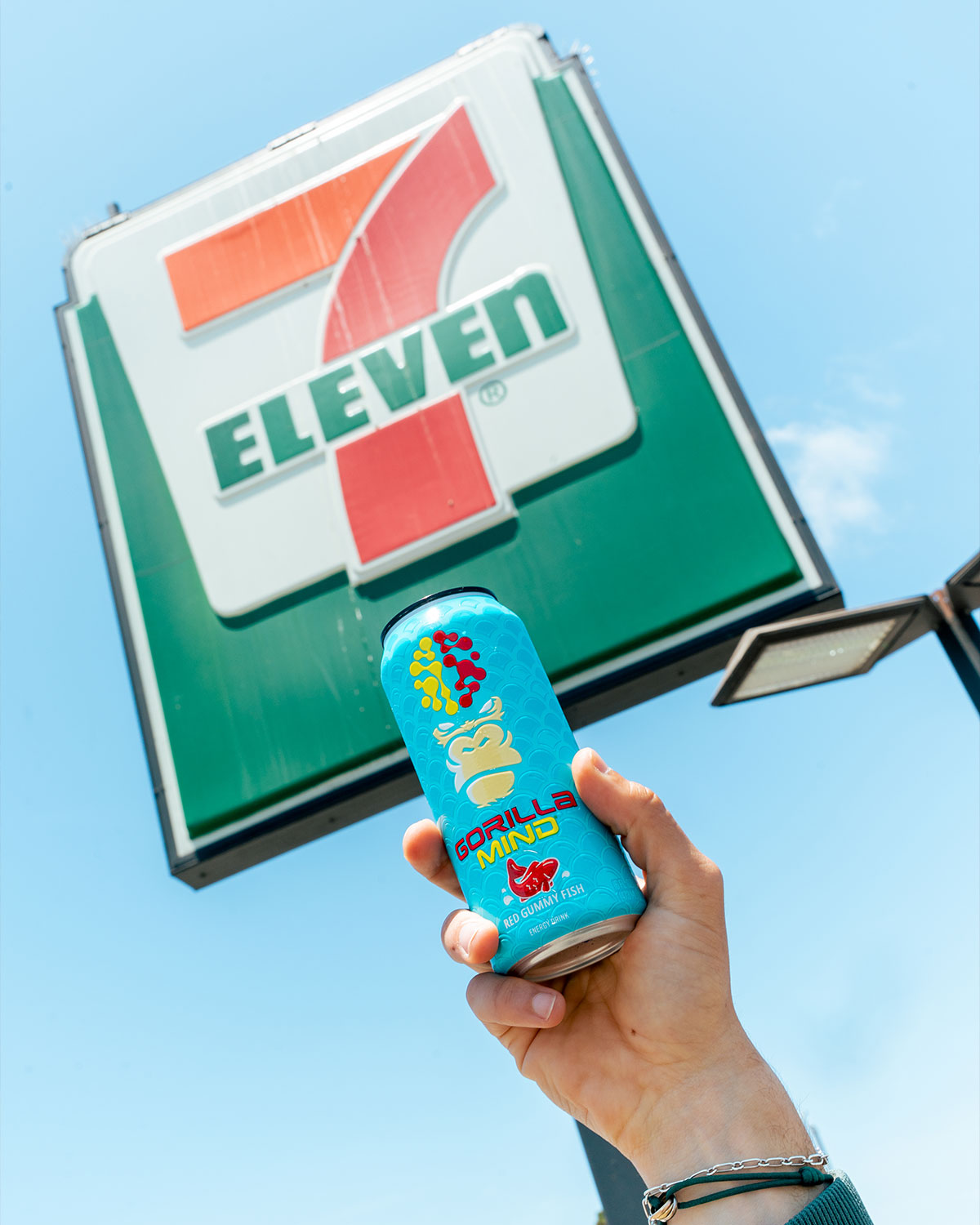 A hand holds a can of Gorilla Mind energy drink in front of a 7-Eleven sign.