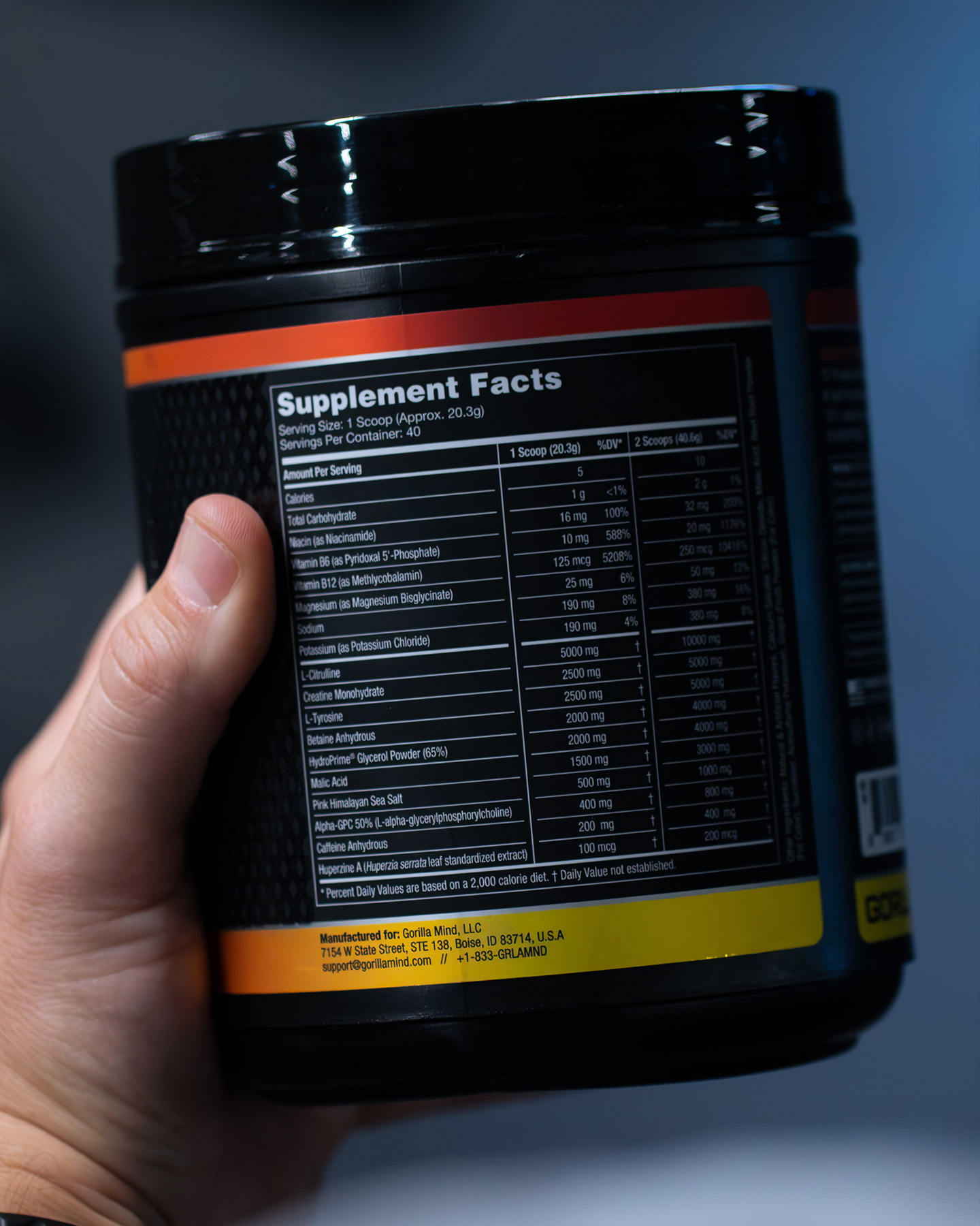 Hand holding a container with supplement facts label.
