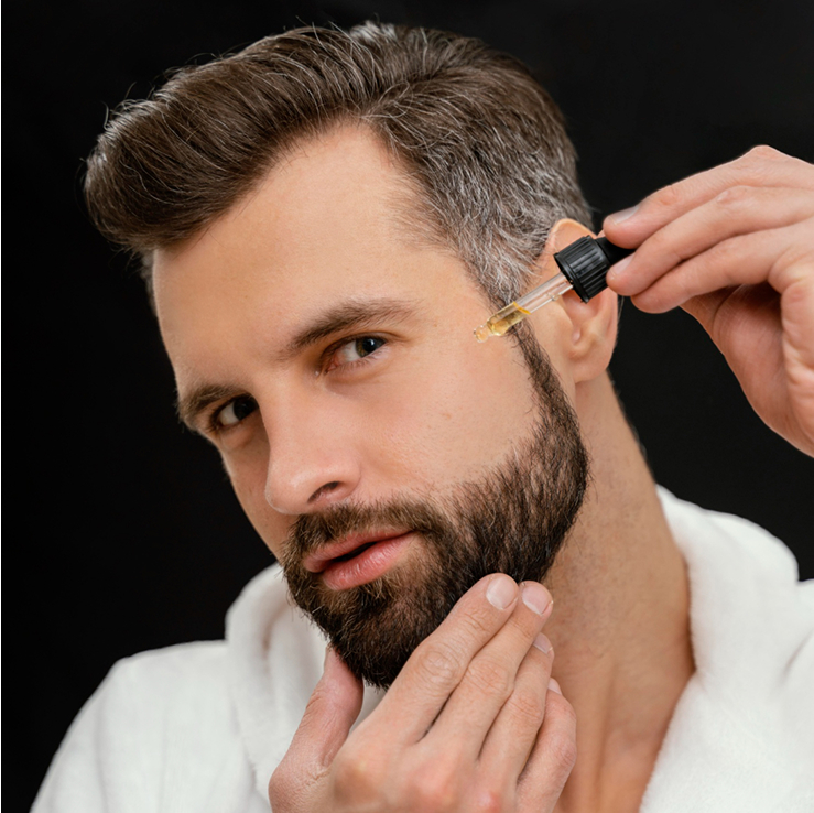 Man applying beard oil with a dropper.