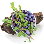 Bowl of blueberries with green leaves on a wooden surface.