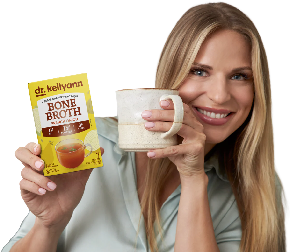 Person holding a mug and a box of bone broth.