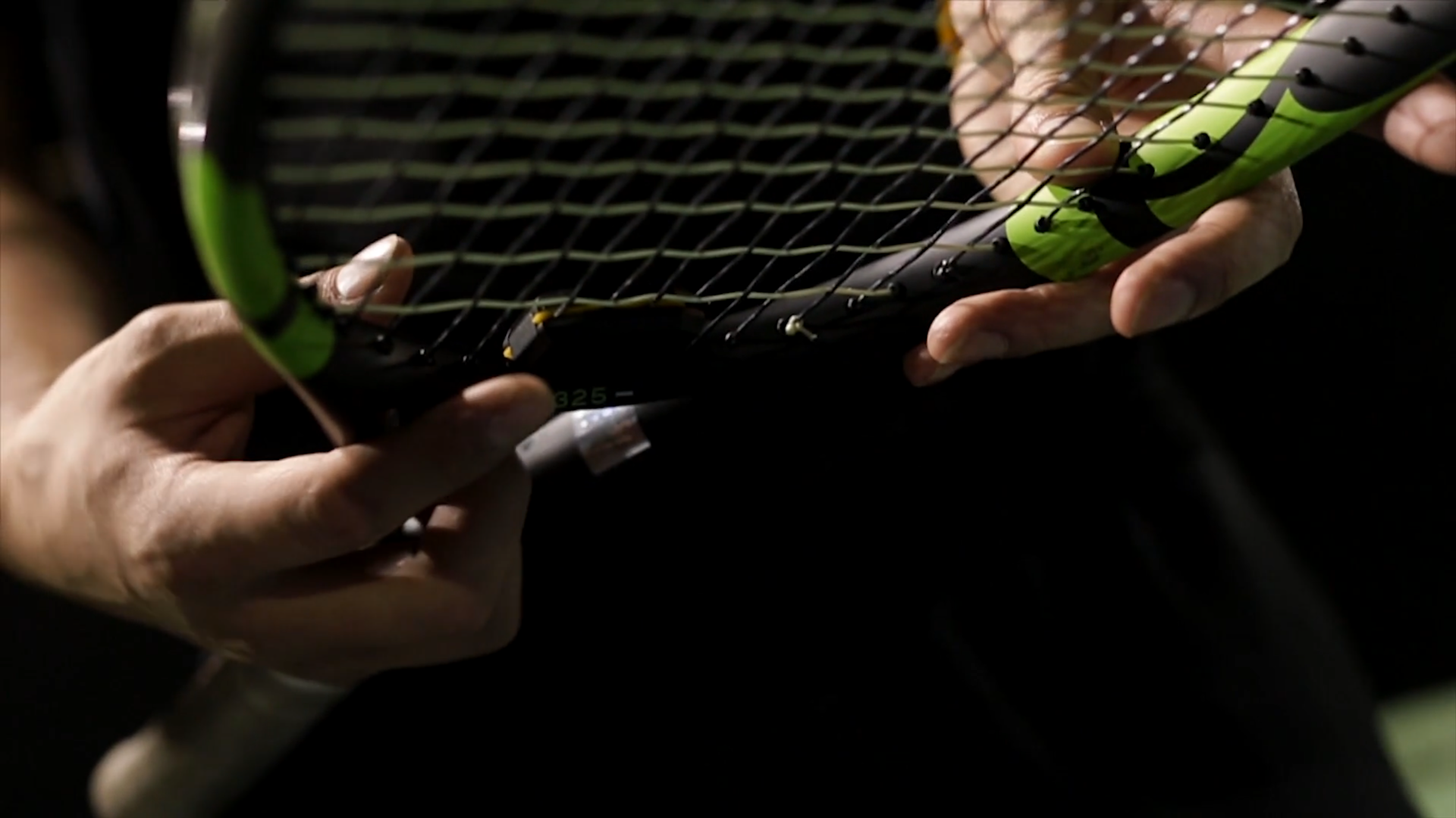 Close-up of hands holding a tennis racket.