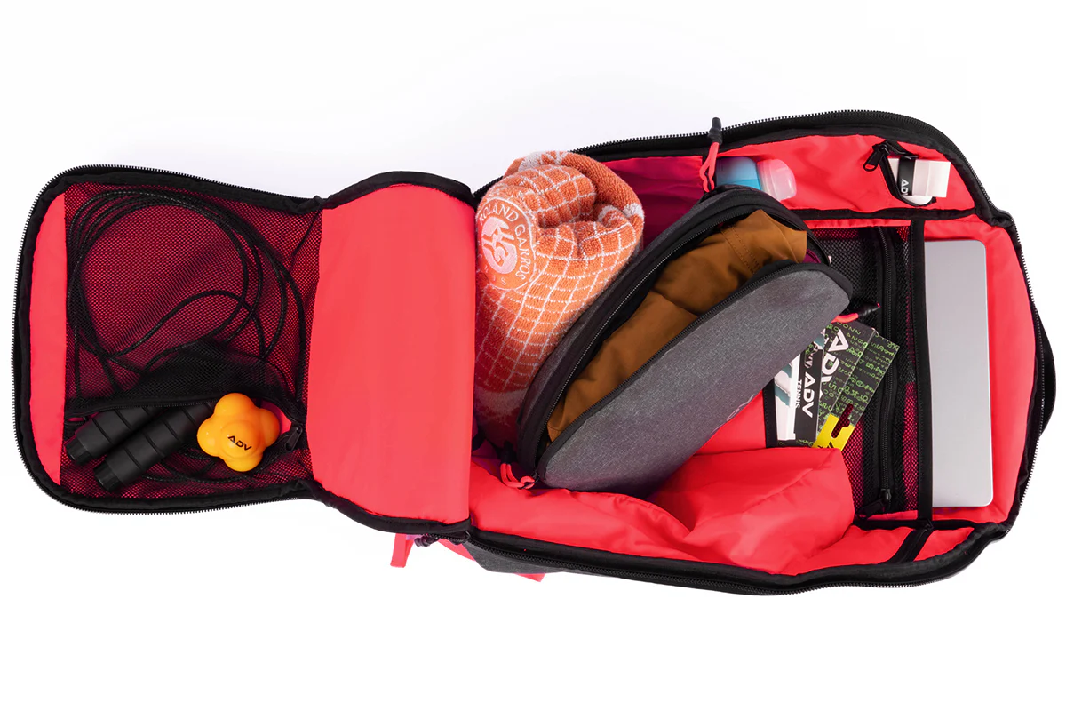 Open backpack with various items including a towel, jump rope, and laptop.