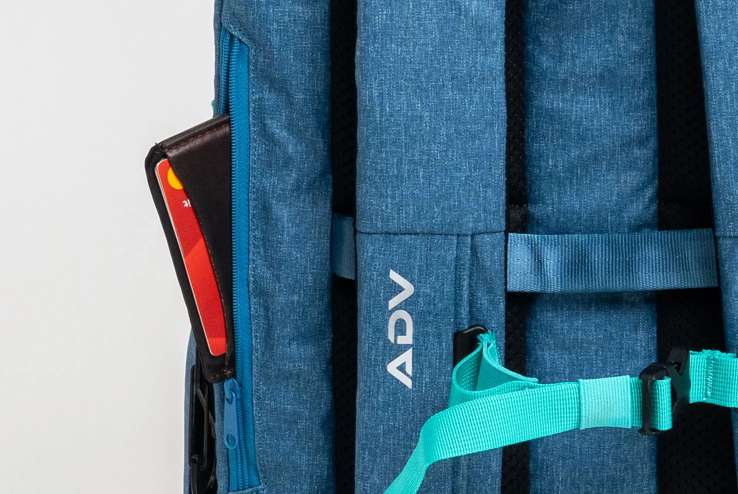 Blue backpack with teal straps and a visible card in the side pocket.