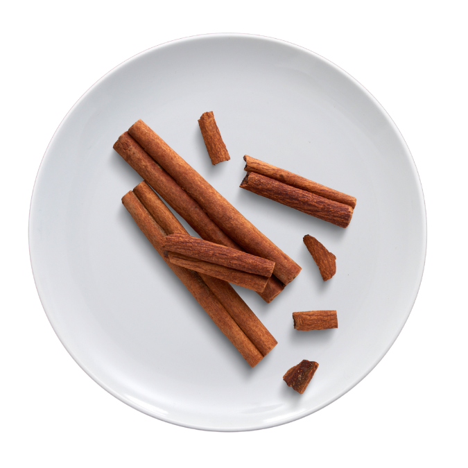 Cinnamon sticks and pieces on a white plate.