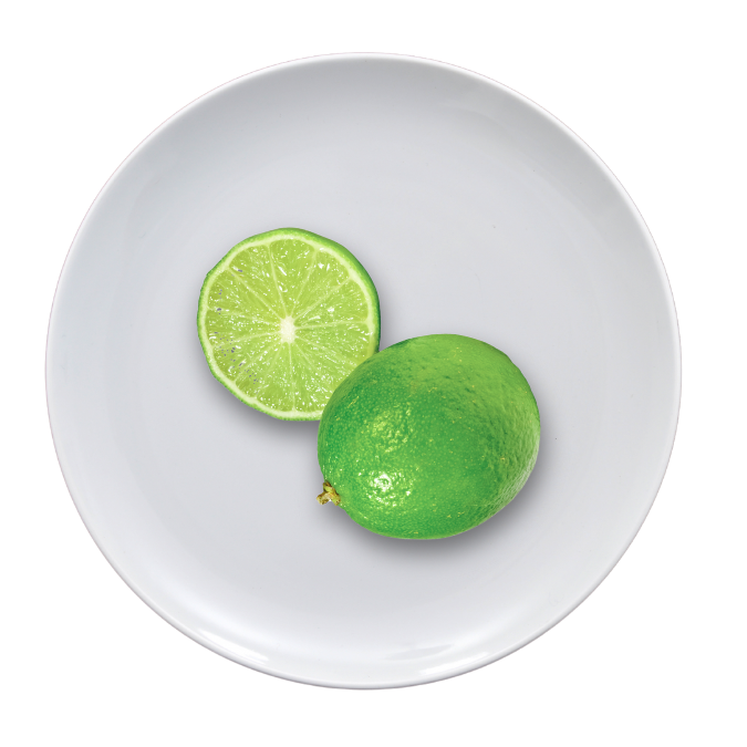Whole and sliced lime on a white plate.