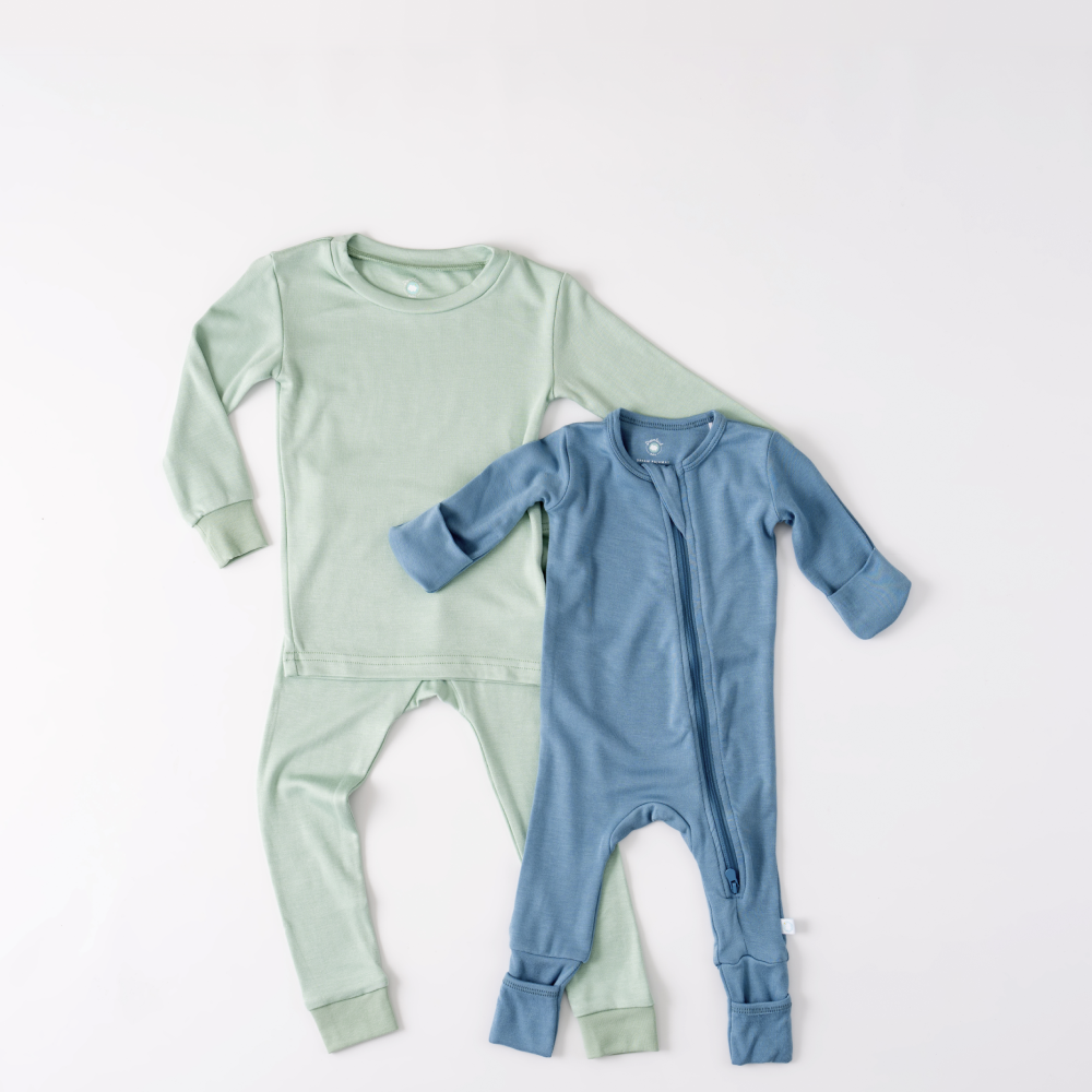 Two baby outfits, one green and one blue, on a white background.