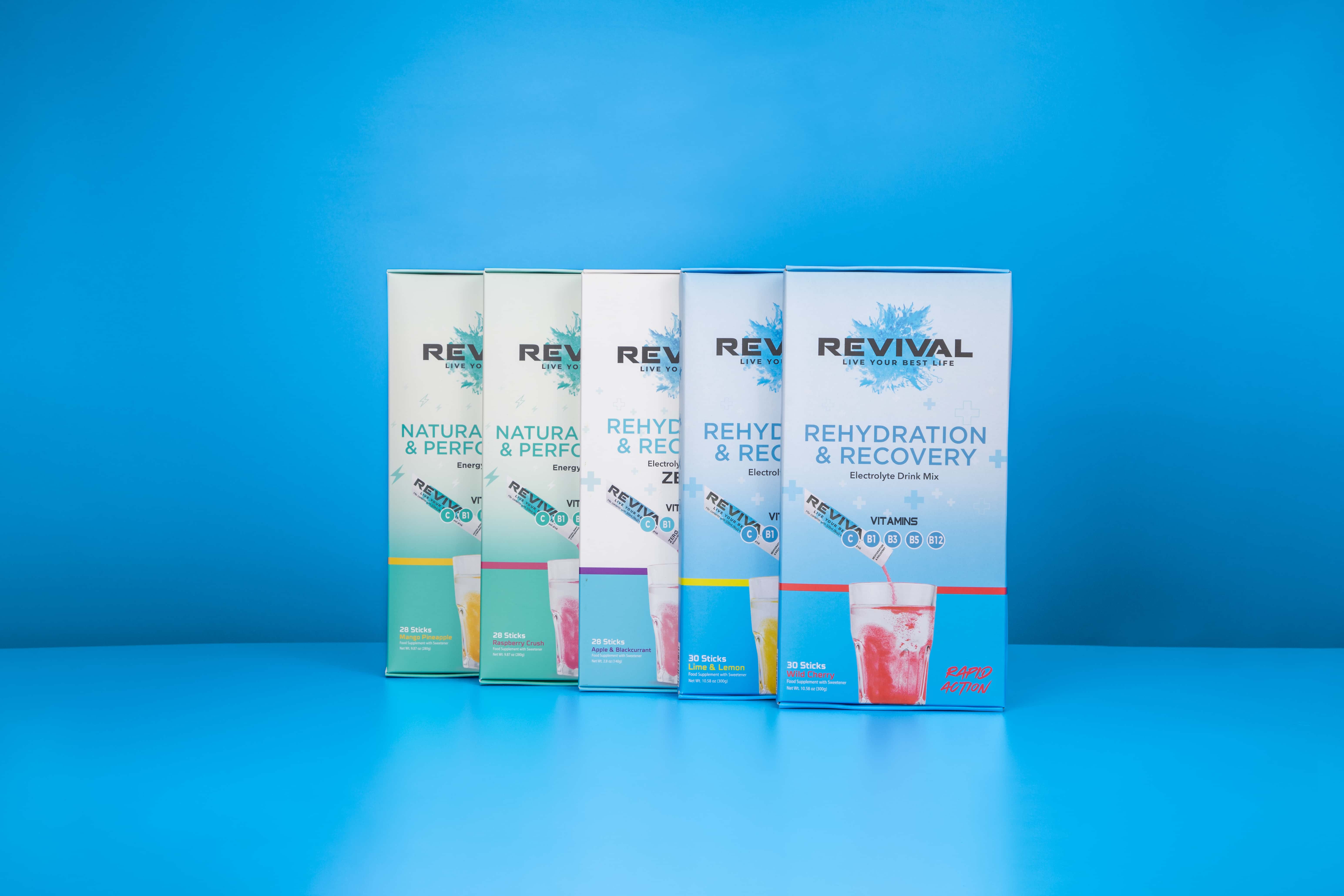 A row of five different boxes of Revival rehydration and recovery drink mix against a blue background.