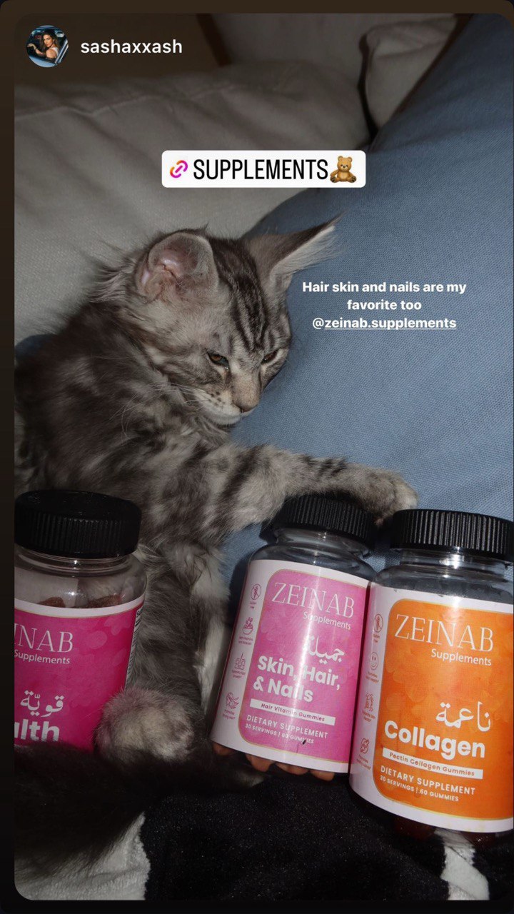 Cat with dietary supplement bottles on a couch, labeled for skin and nails.