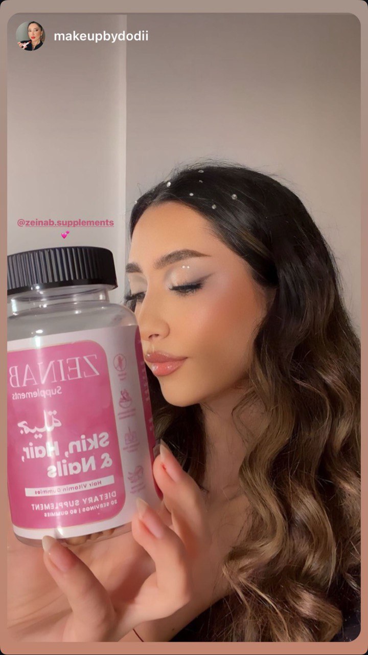 Person holding a bottle of skin, hair, and nails supplements.