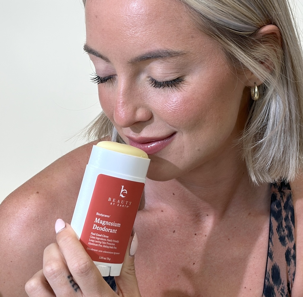 Person holding and smelling a stick of magnesium deodorant.
