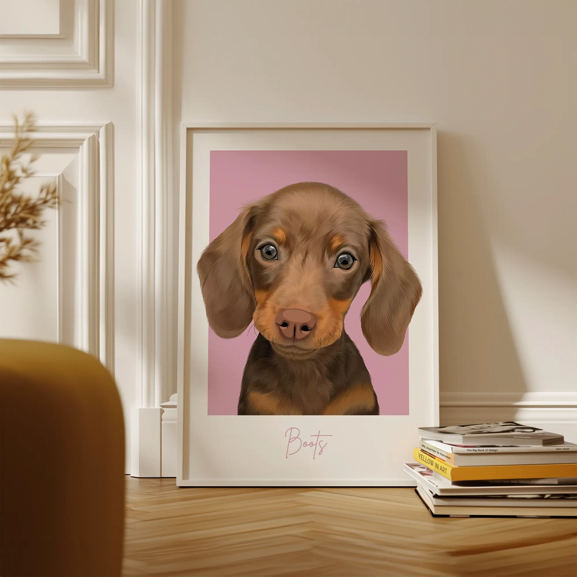 Framed illustration of a puppy with a pink background, next to a stack of books.