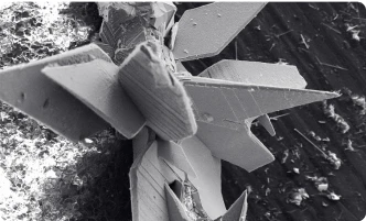 Close-up of a geometric, crystalline structure on a black surface.