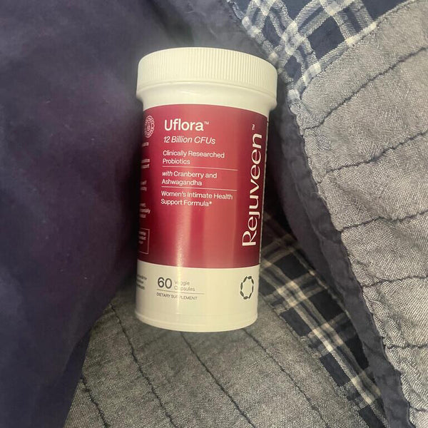 A bottle of Uflora probiotics on a plaid fabric background.