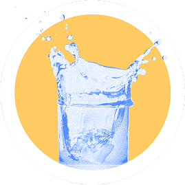 A splash of blue liquid in a glass against a yellow background.