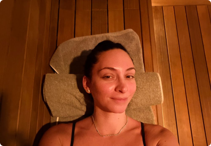 Woman relaxing on a towel inside a wooden sauna