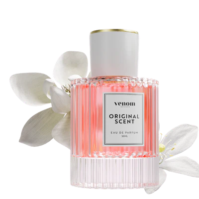 A ribbed glass bottle of pink Venom Original Scent perfume rests amongst white flowers.