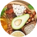 A variety of healthy foods including avocado, nuts, seeds, and dried fruits.
