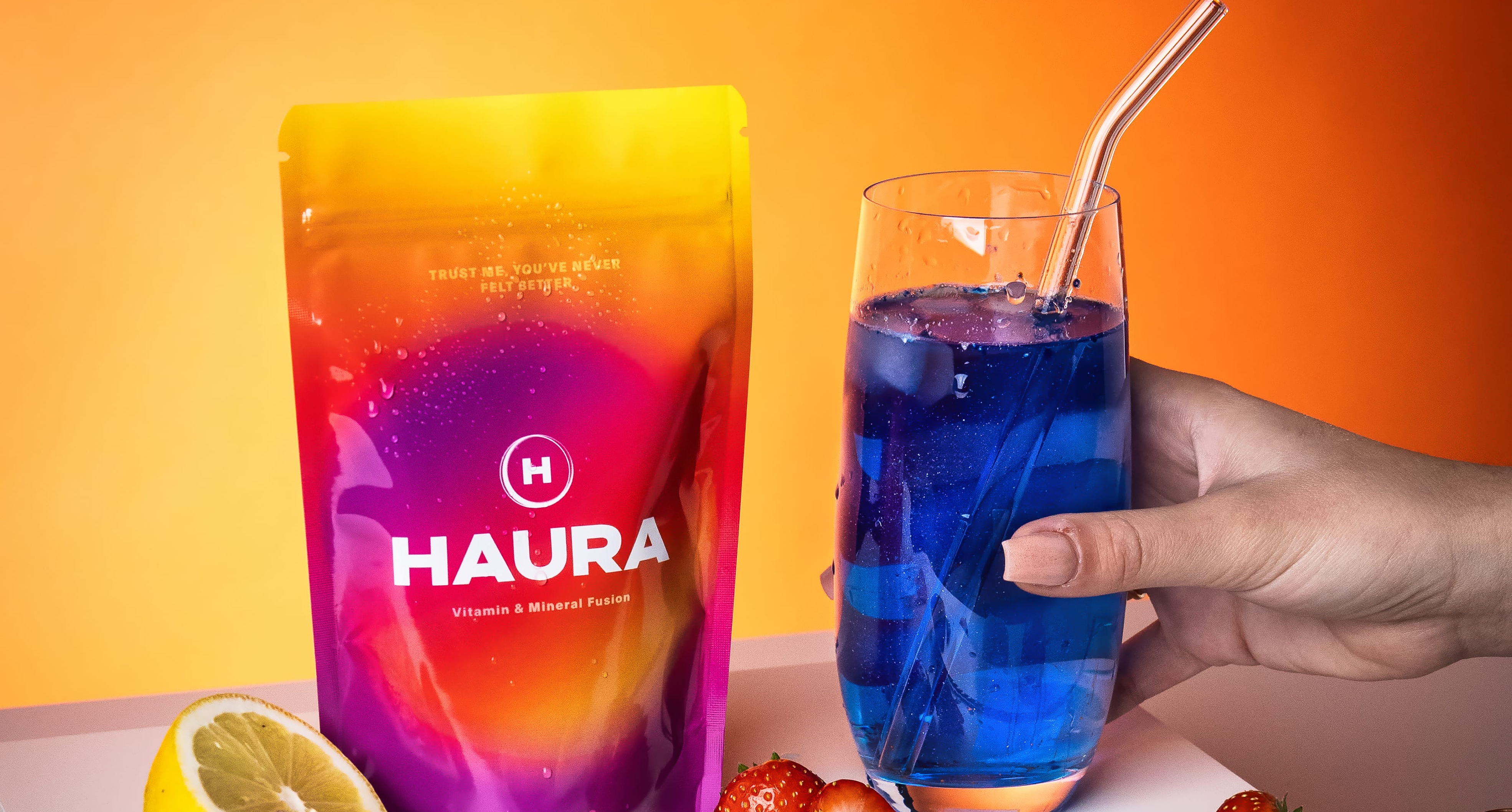 Colorful vitamin package and blue drink with a lemon slice and strawberries.