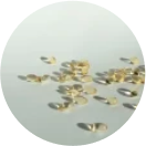 Scattered golden capsules on a white surface.