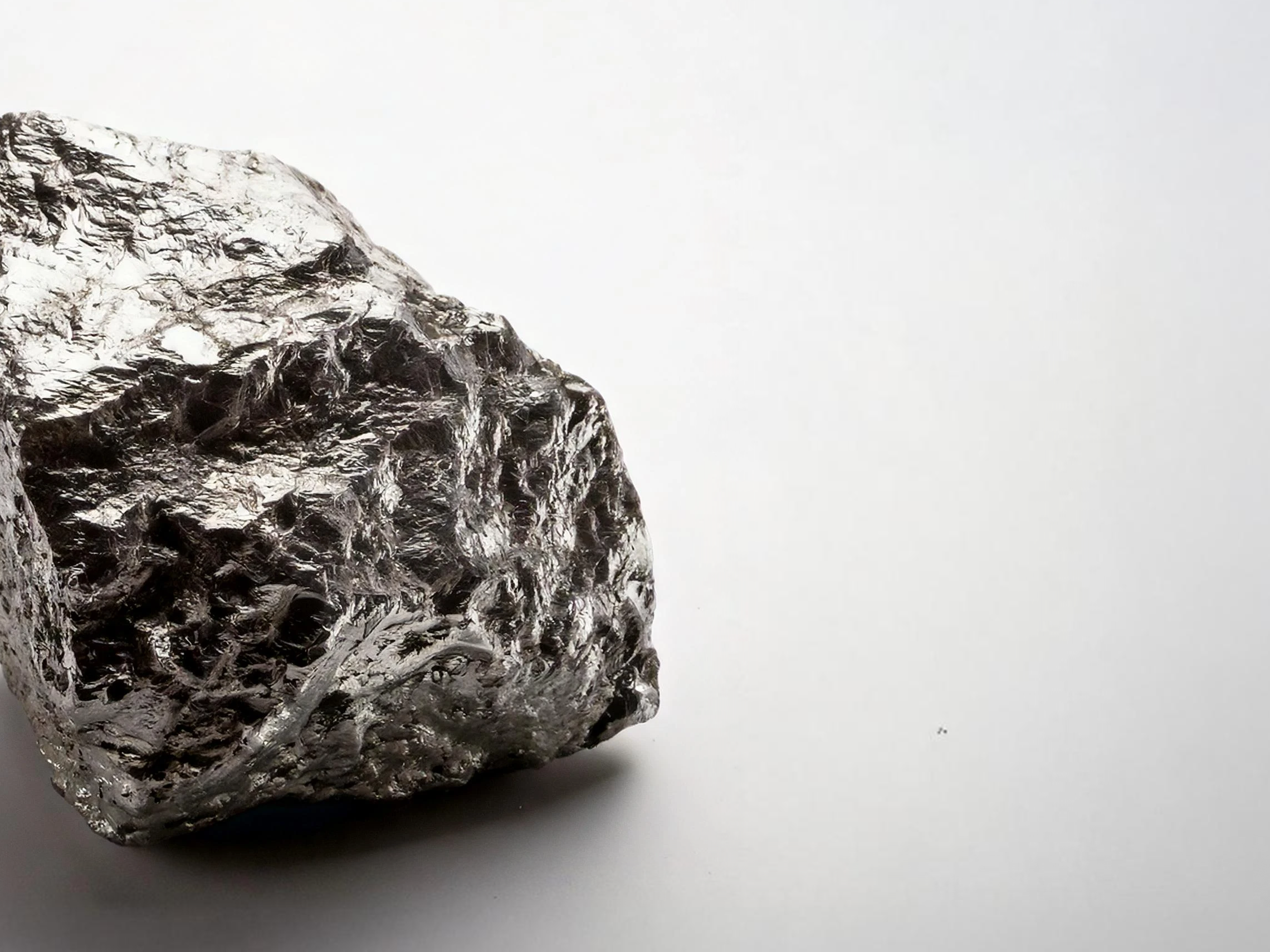 Rough metallic mineral rock on a plain white background.