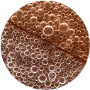 Close-up of numerous bubbles in a liquid, creating a textured pattern.