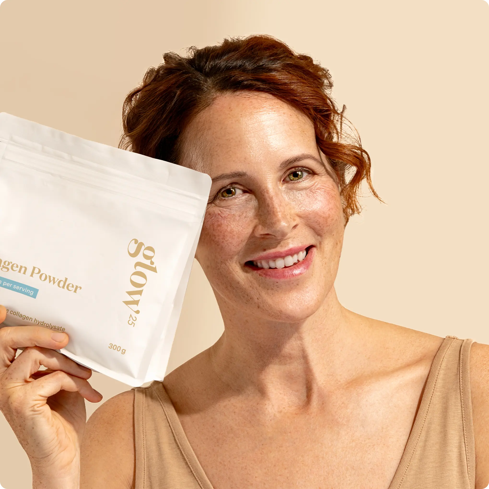 Smiling person holding a package labeled 'glow' collagen powder.