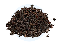 A circular pile of dark, loose-leaf tea on a green background.