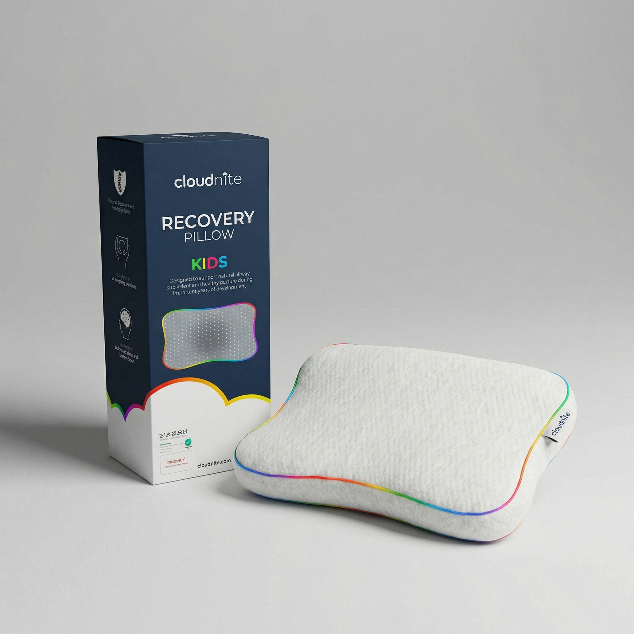 A white pillow with rainbow trim next to its blue branded carrying case.