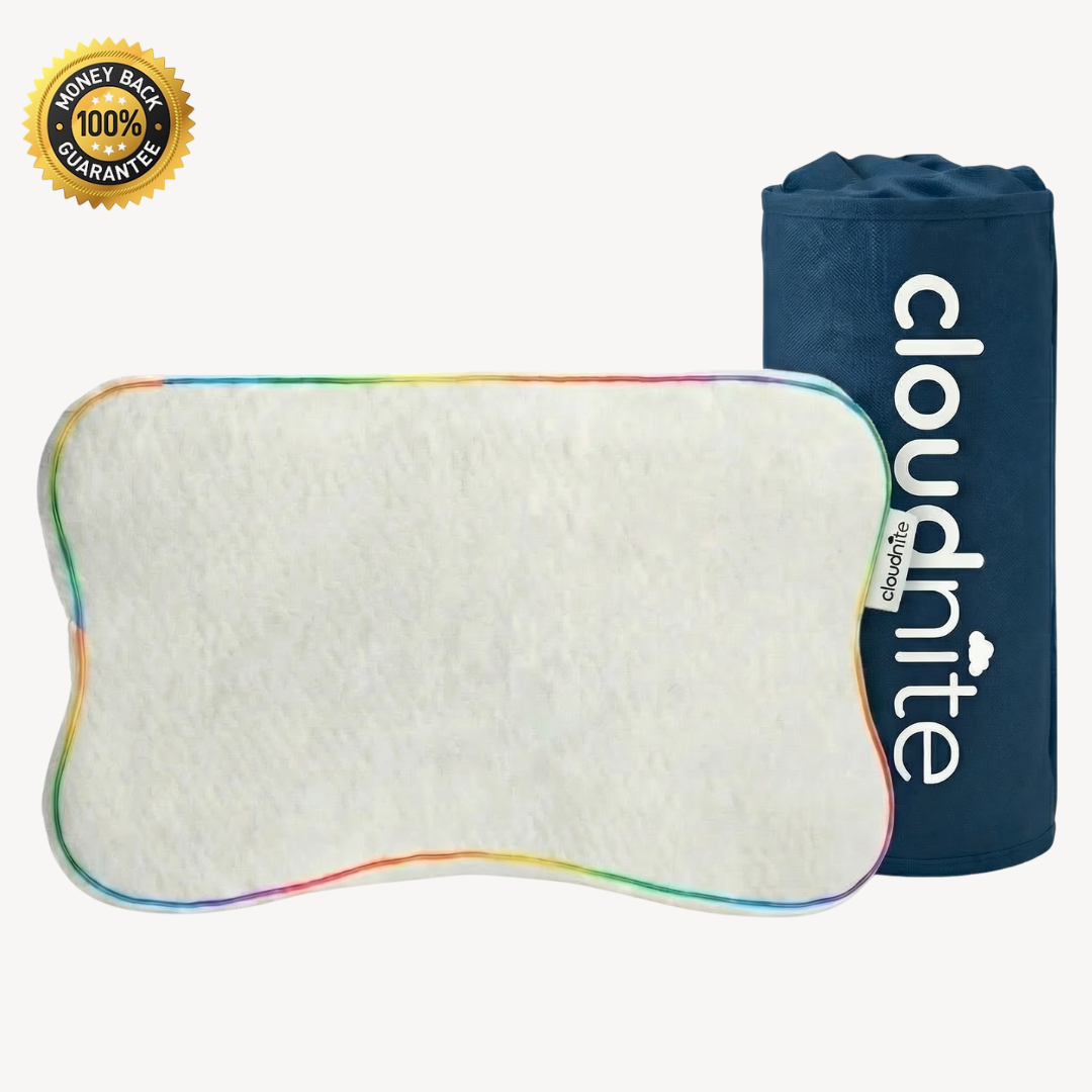 A white, bone-shaped pillow with rainbow-colored trim sits next to its blue carrying bag.