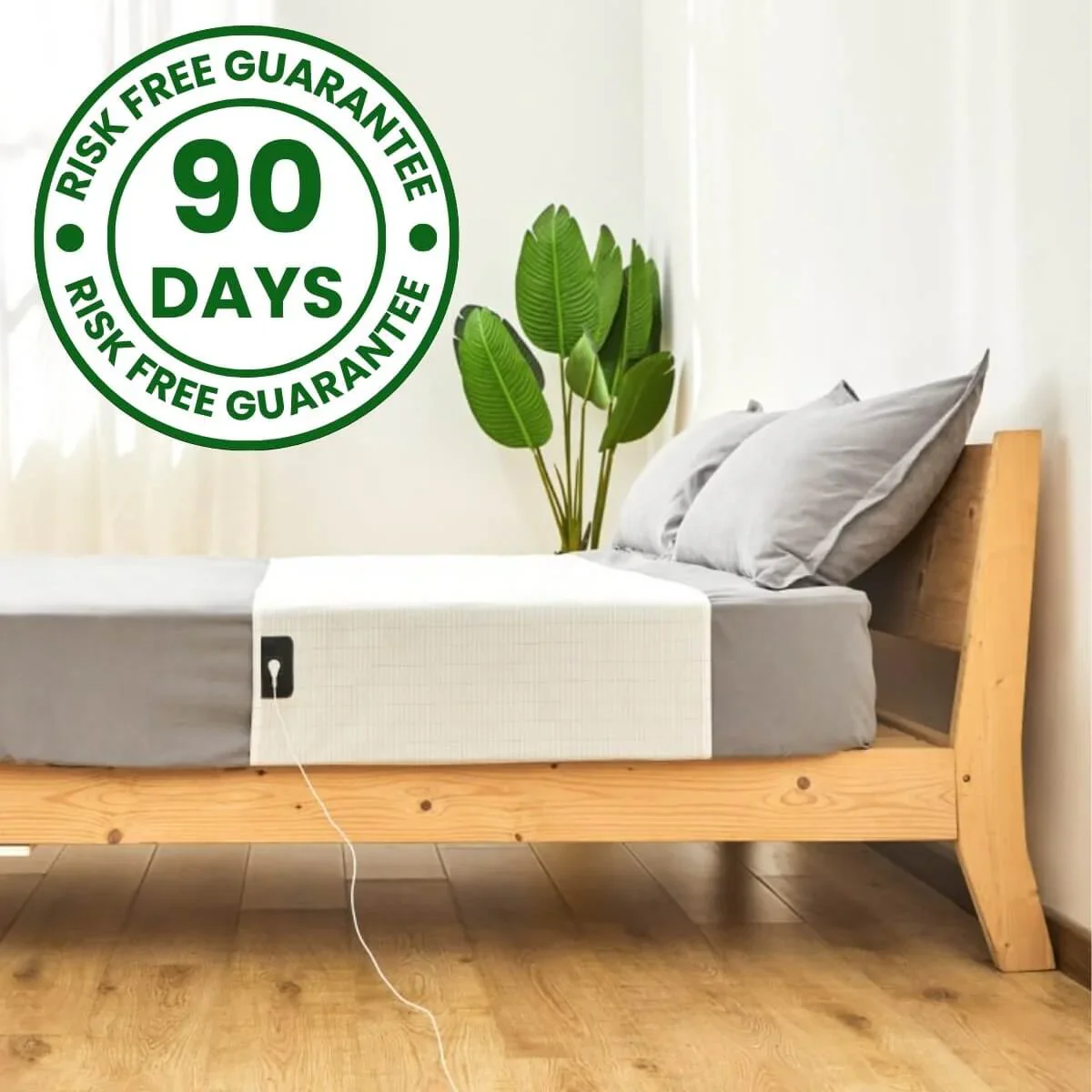 A white mat with a cord lying on a bed, with a '90 Days Risk Free Guarantee' emblem.