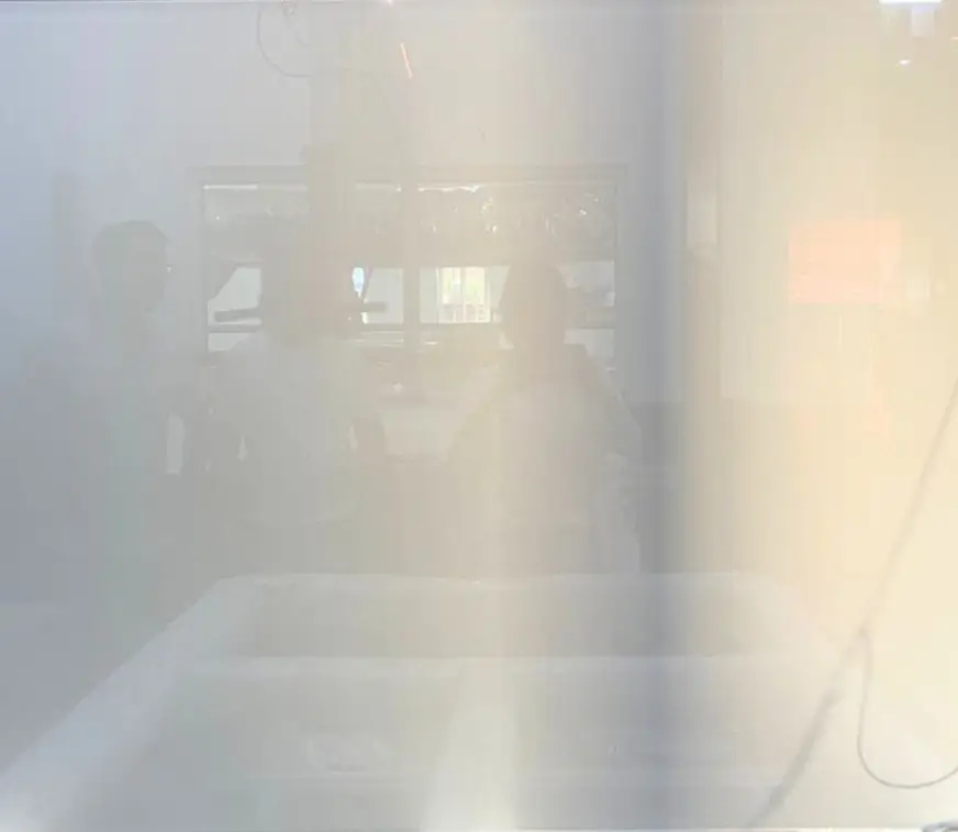 Blurry image with silhouettes of people and soft lighting.