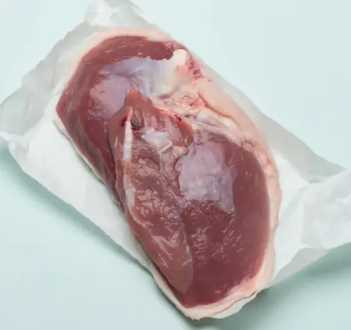 Raw meat on paper against a light background.