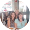 Three people seated at a table indoors, smiling at the camera.