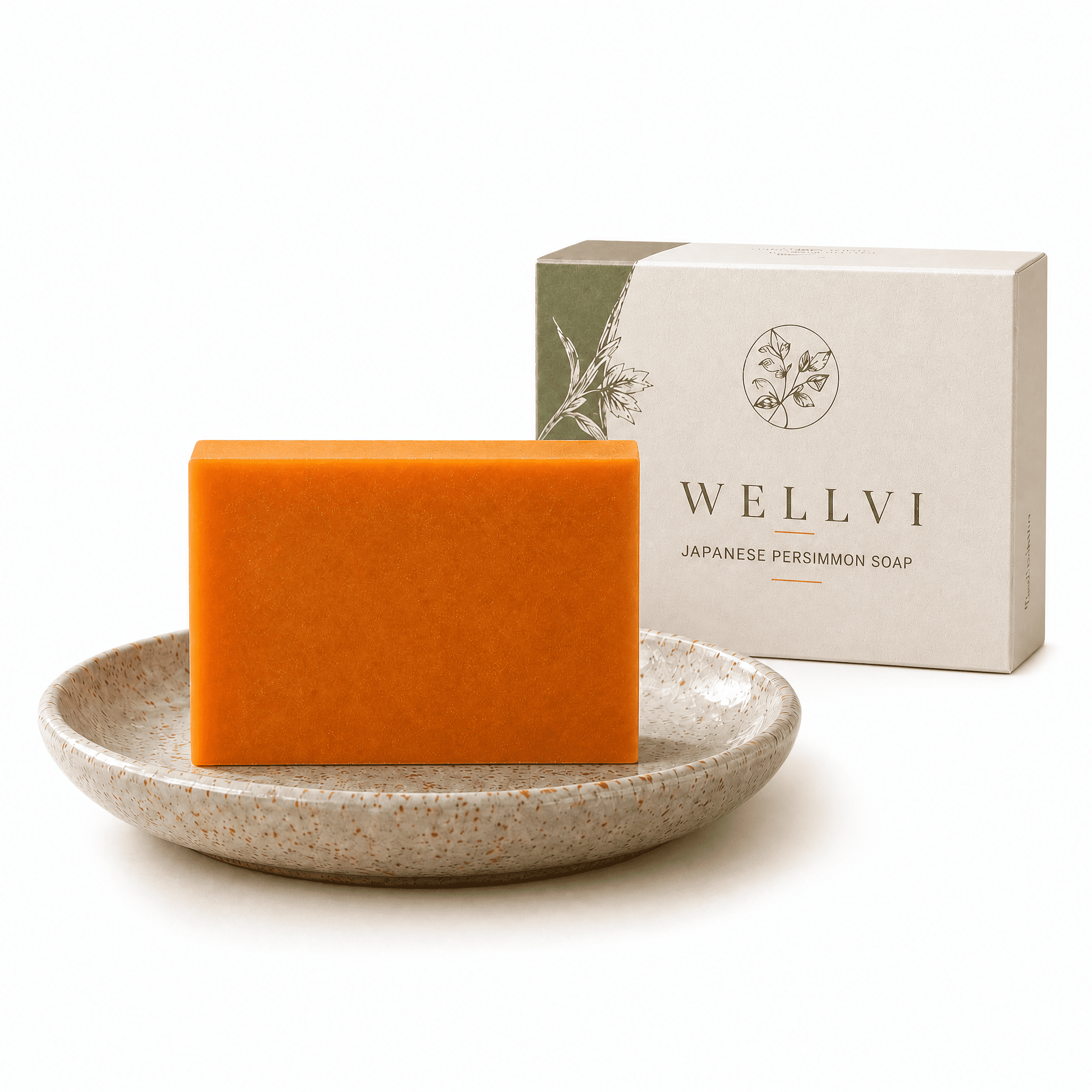 A bar of orange soap rests on a speckled ceramic dish next to its white and green box.