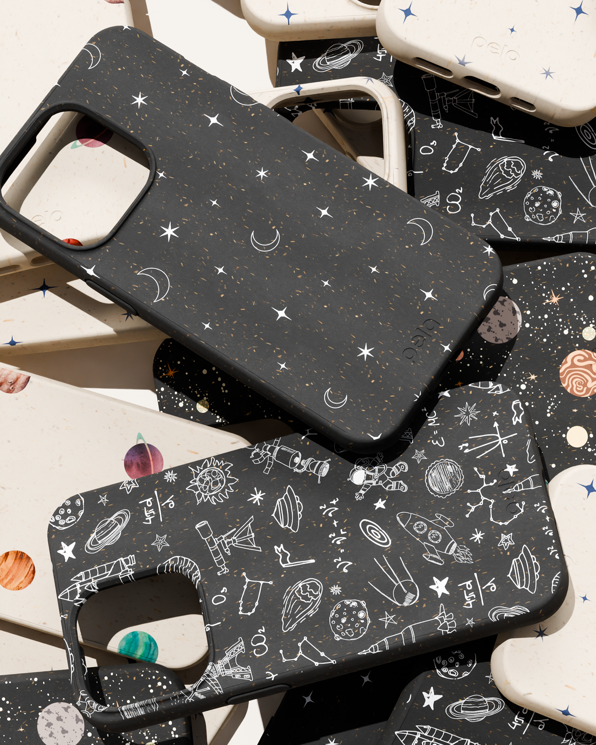 A pile of black and white phone cases with various space-themed designs and illustrations.